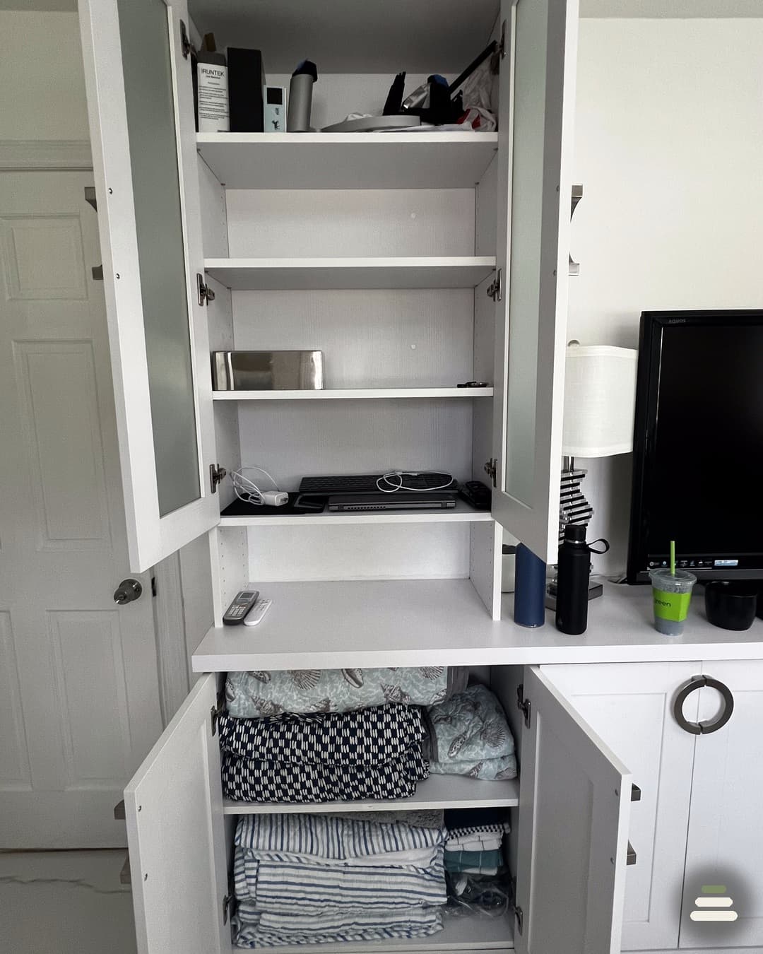 Zoned closet system separating home office supplies and bedding storage